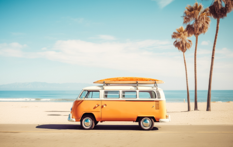 Yellow and white VW Van on beach with surfboard