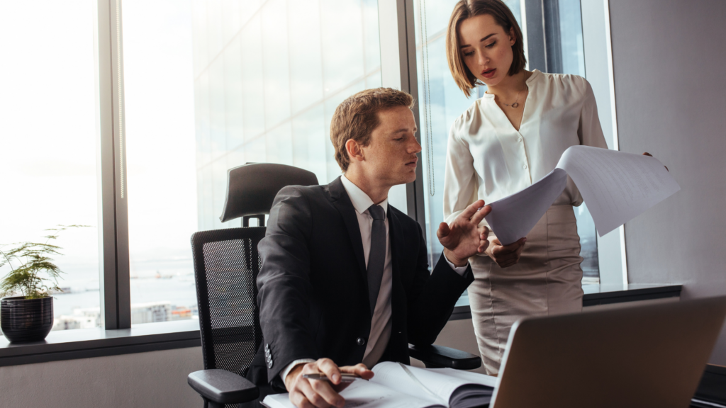 Two legal professionals looking over documents in office setting at desk