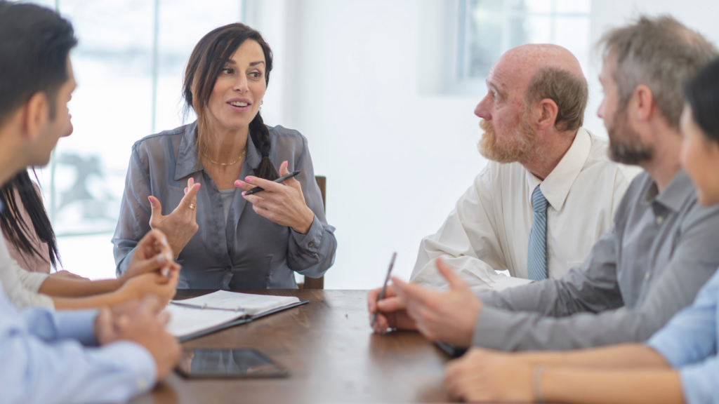 group of business professionals smiling around conference table