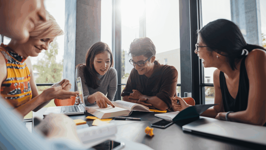 law students at a table in study session with books and devices