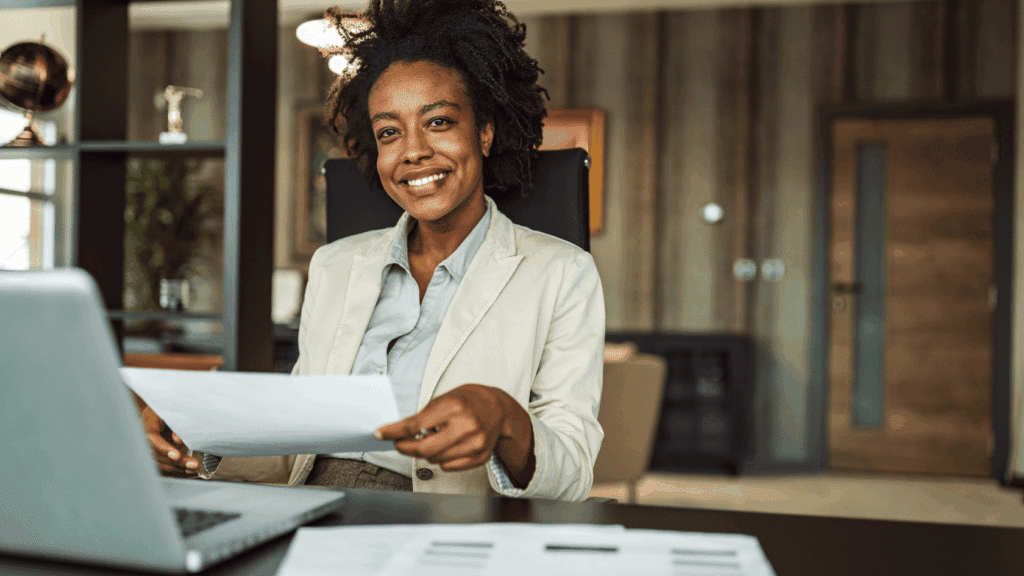 Young business professional woman at desk with laptop smiling
