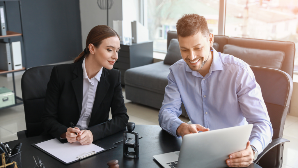 Employer compliance updates and new laws being reviewed by two business workers in a corporate office