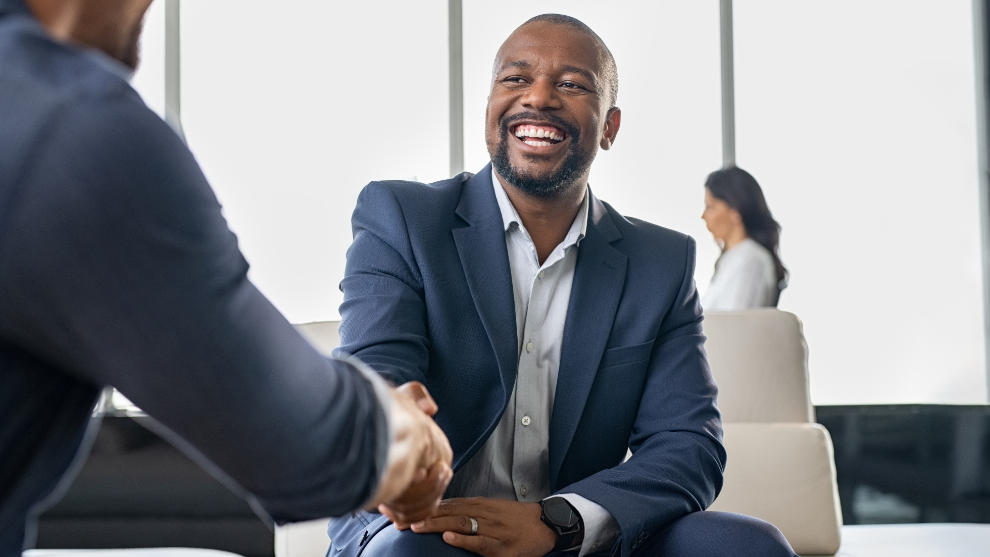 Business men shaking hands in corporate lobby