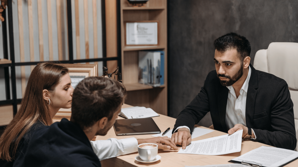 Attorney with couple at desk covering California spousal support calculation documents